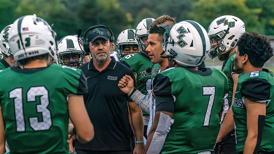 Football coaches talking to players during a game