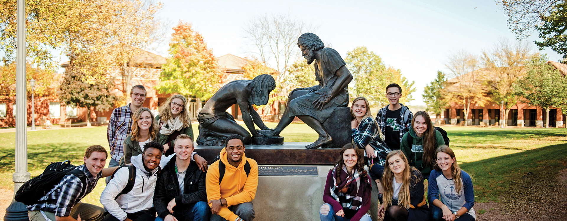 Group of WLC students near the Divine Servant Statue in the Quad