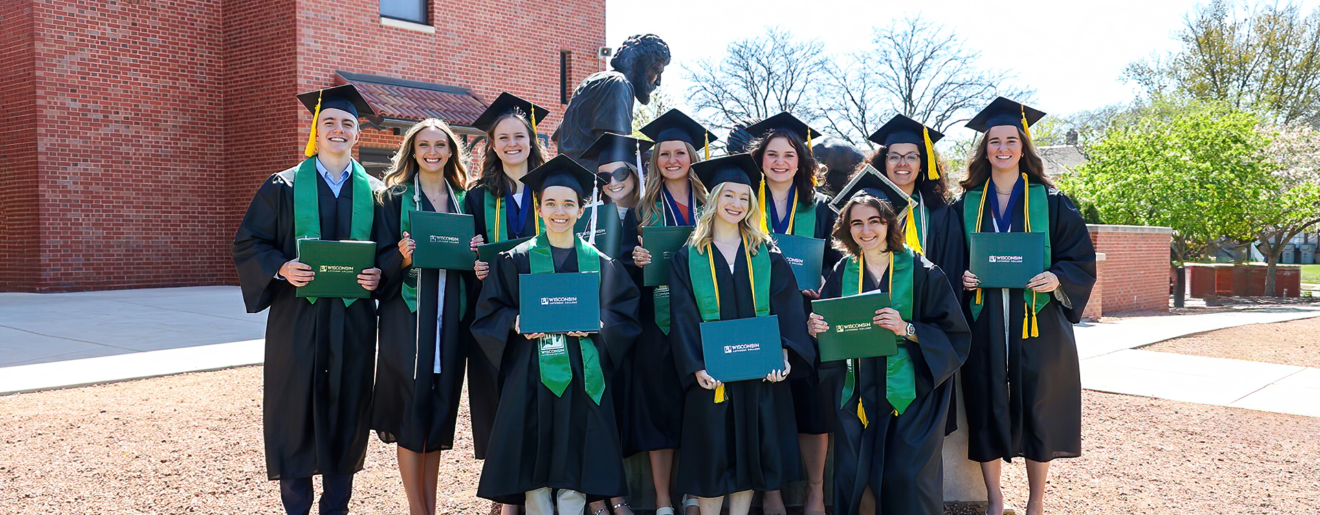 Grads by Divine Servant statue