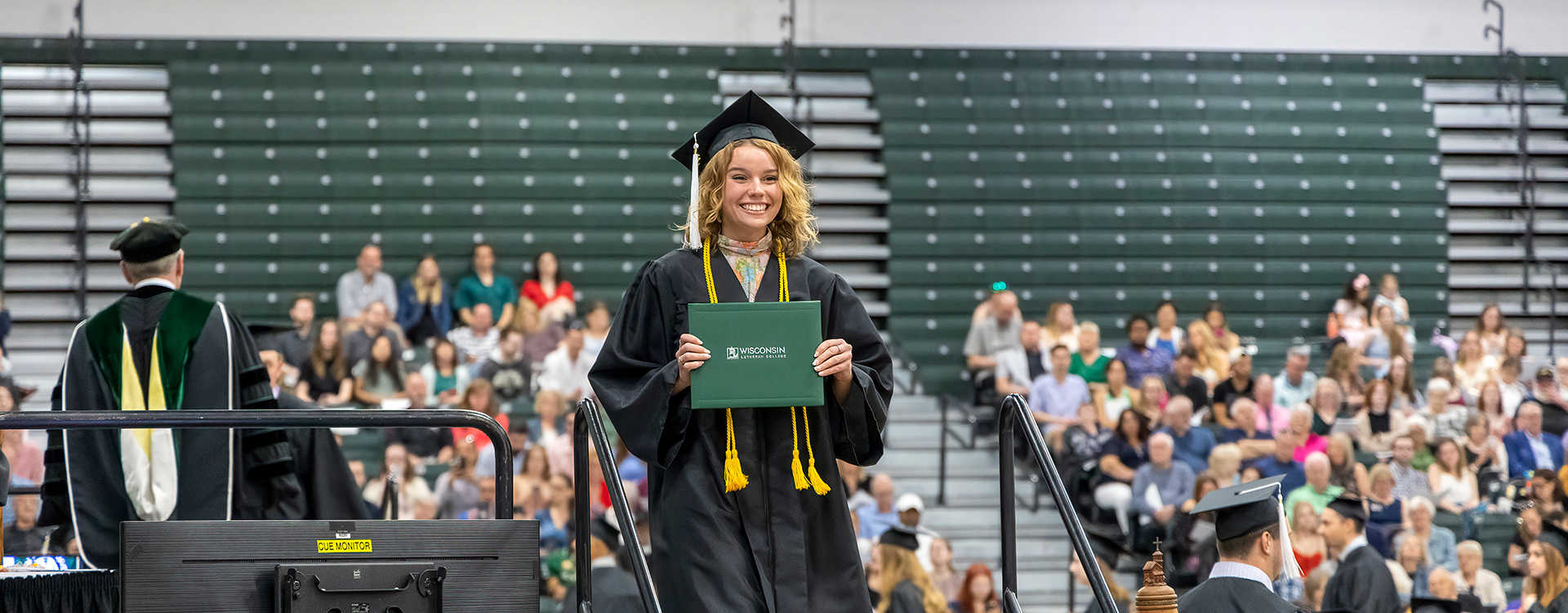 Graduate on stage with diploma at commencement