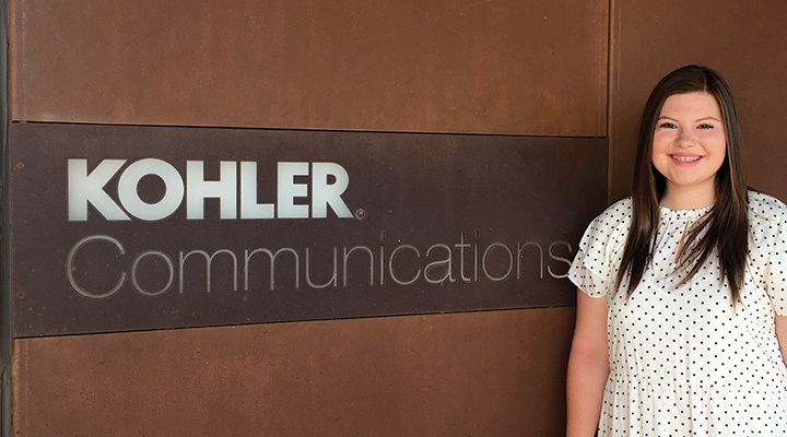 Student in front of sign at internship