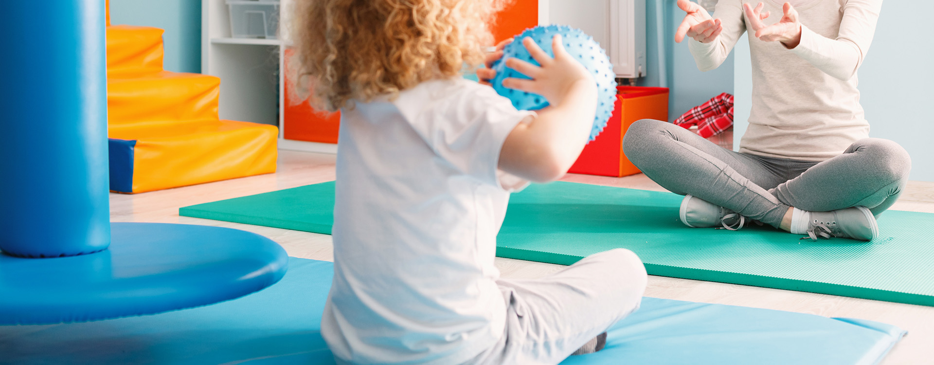 Small boy with ball in occupational therapy setting