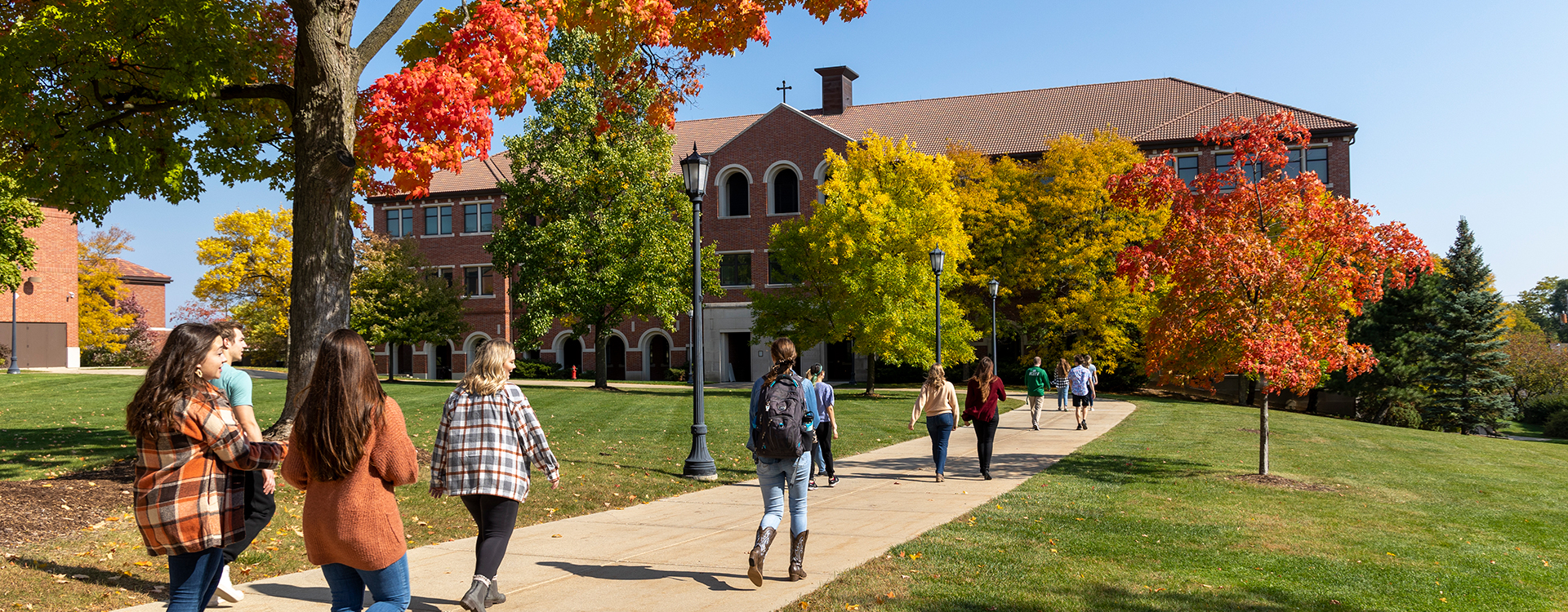 Students walking into Generac Hall in autumn