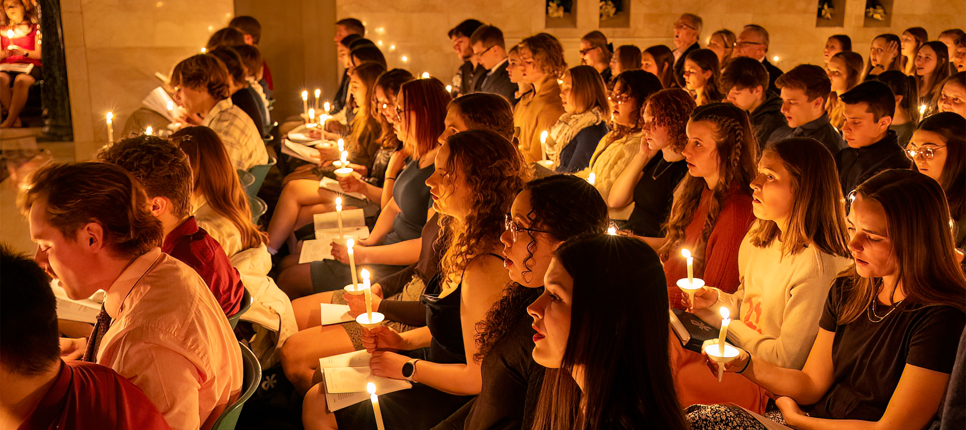 Students holding candles in chapel