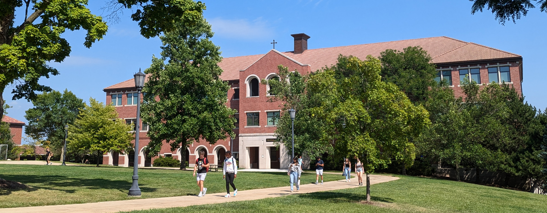 students walking in front of Generac Hall in summer