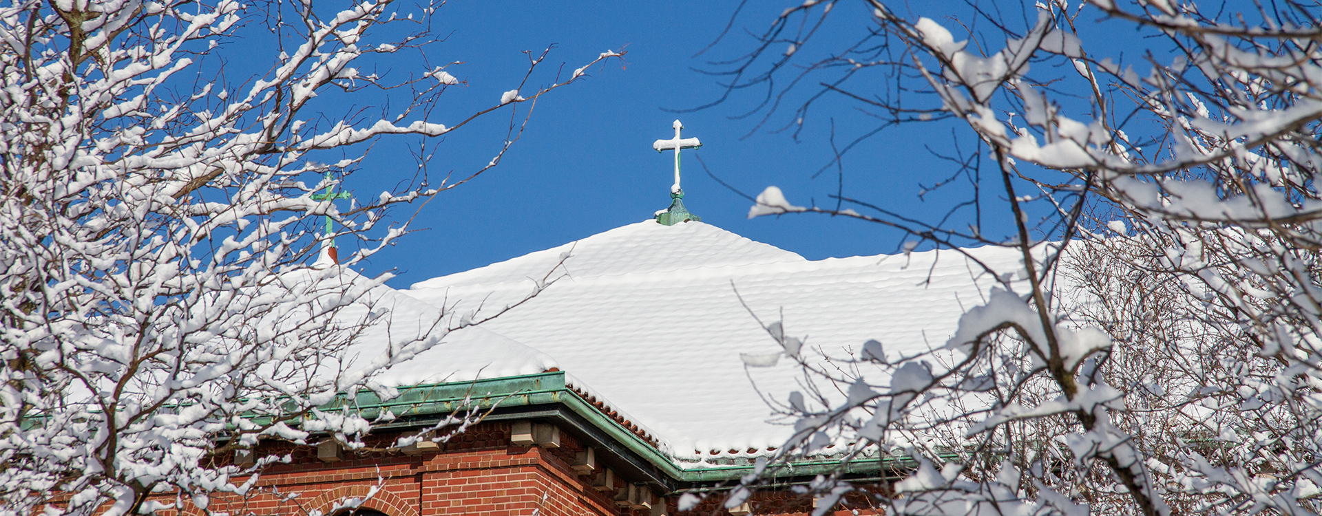 Snow on a rooftop cross